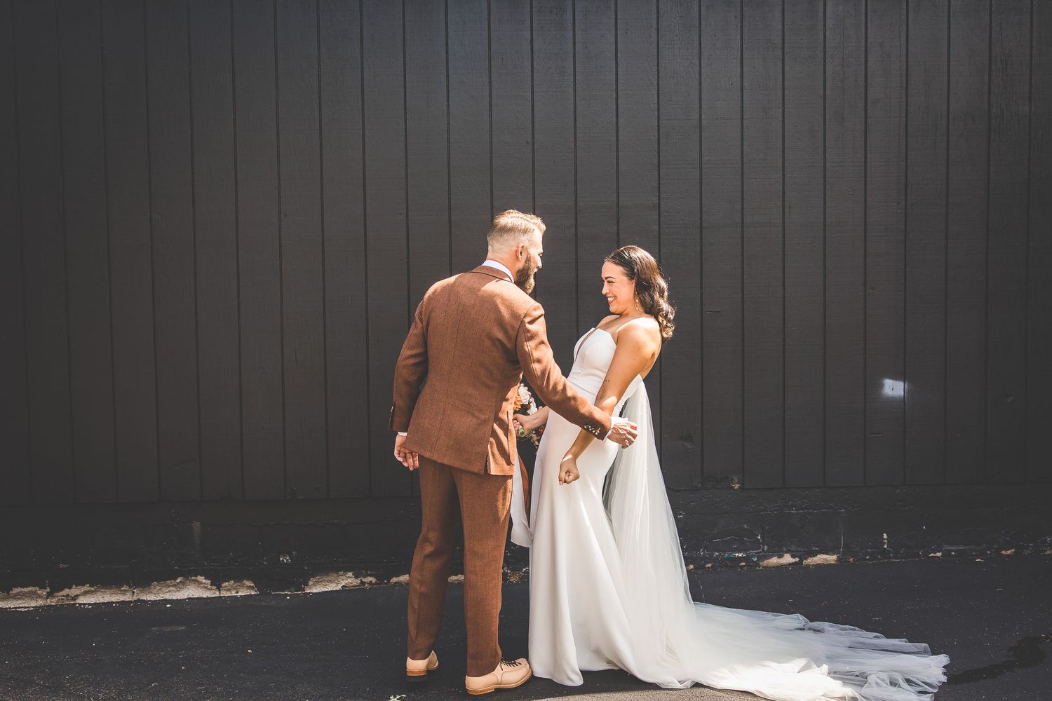 Romantic wedding portraits against a dark wooden backdrop with dramatic lighting.