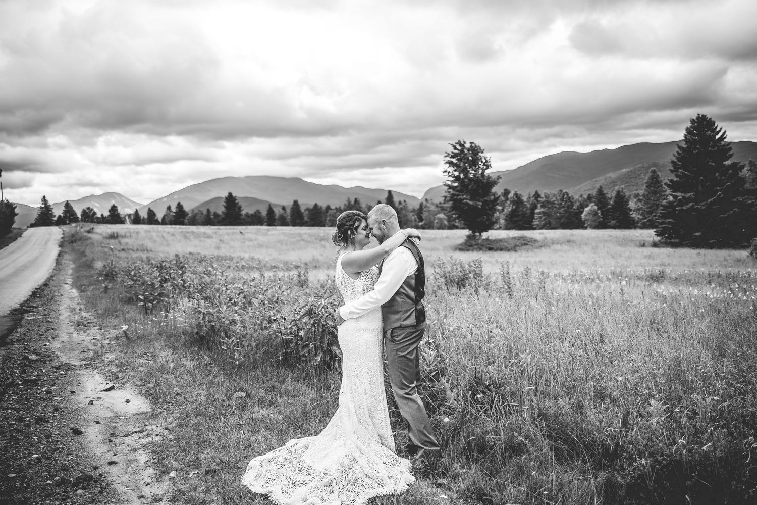 Romantic wedding photos captured in a wild meadow with mountain vistas.