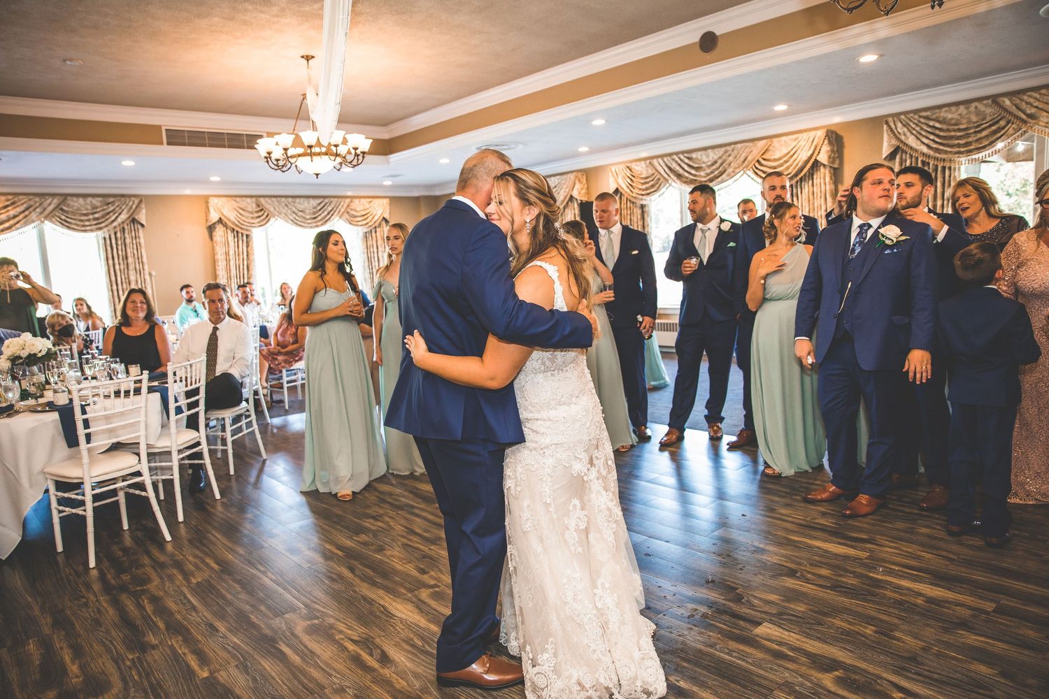 Elegant wedding reception venue with hardwood floors and crystal chandeliers.