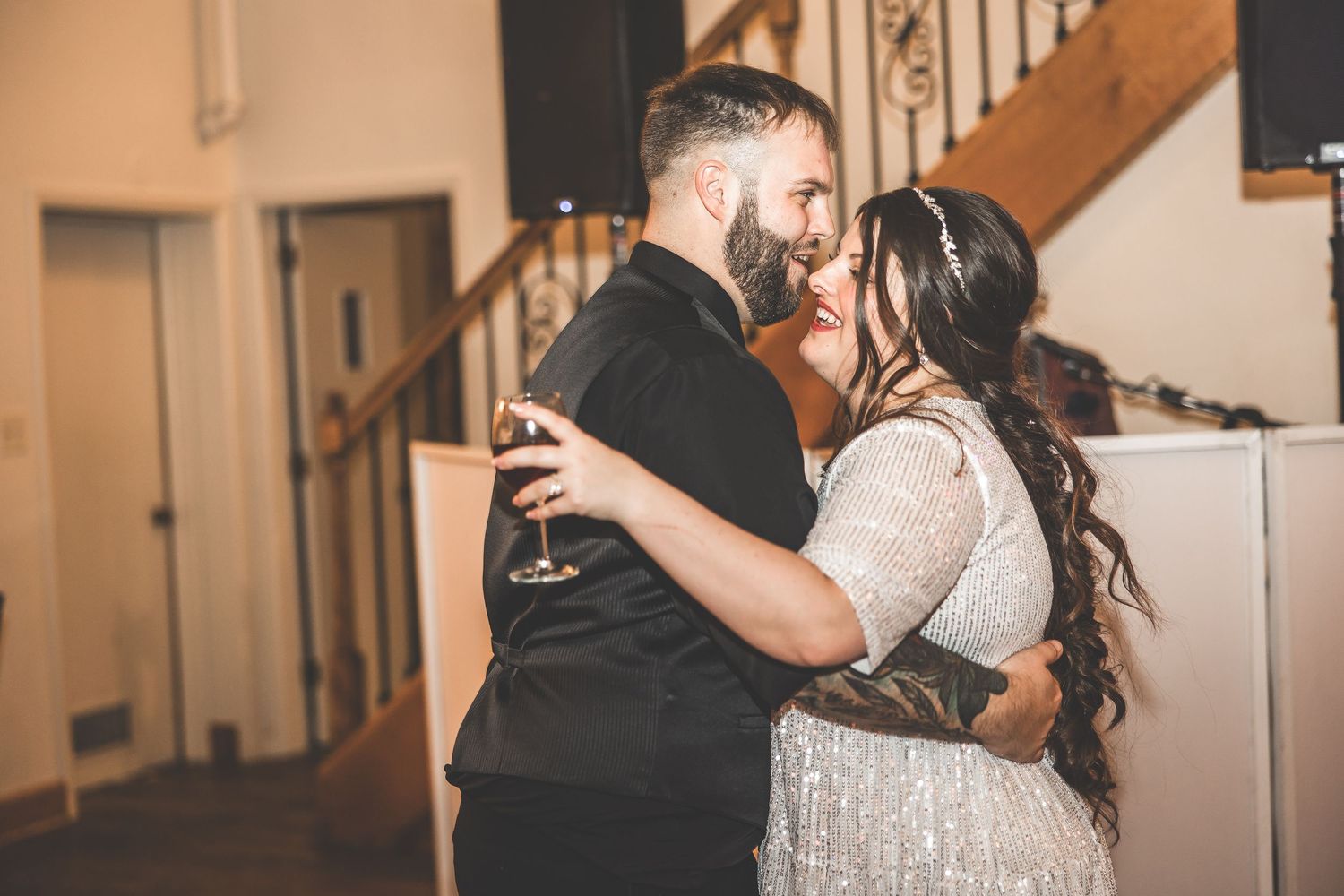 Wedding reception dance floor moments captured in front of an elegant staircase.