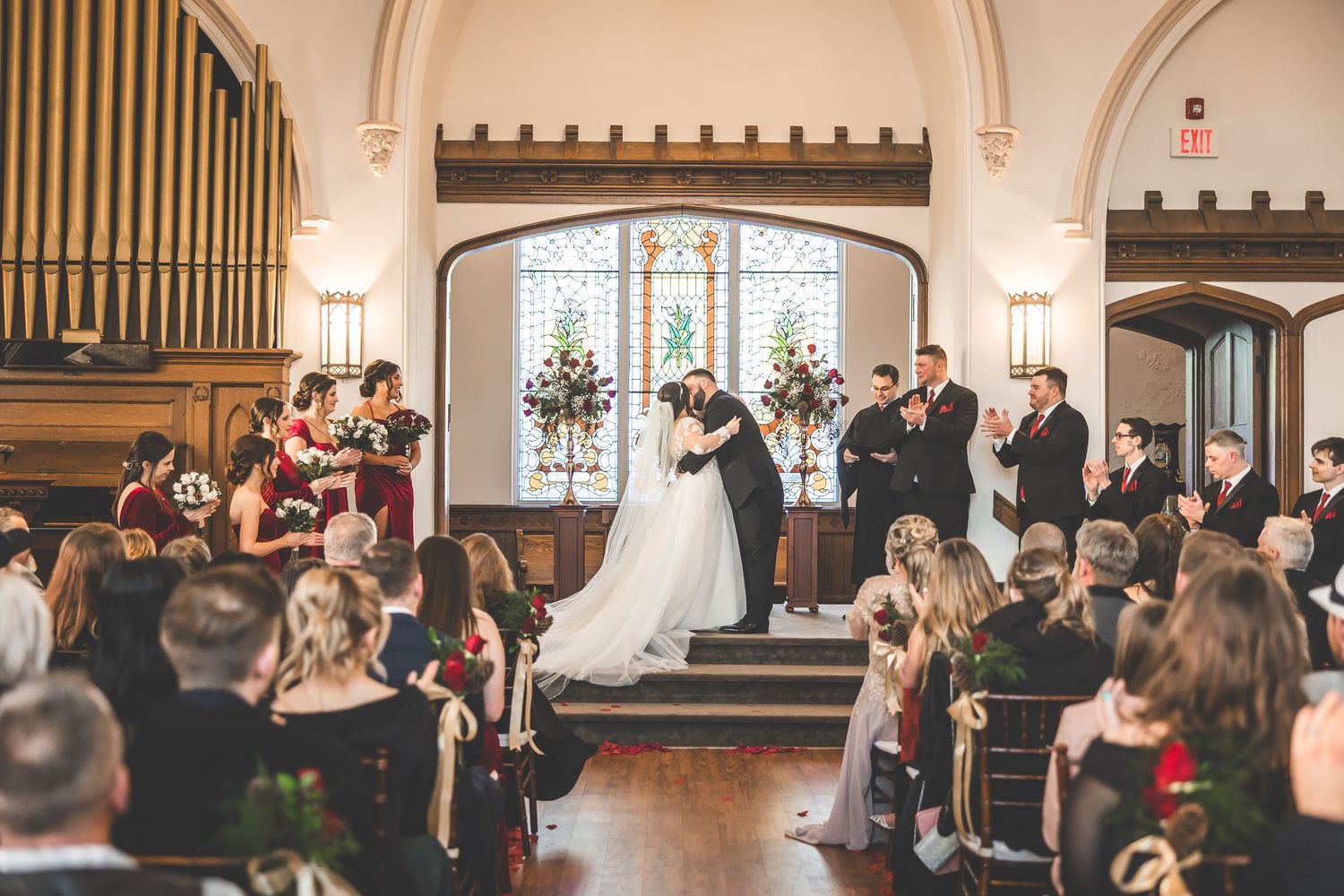 Interior view of church wedding ceremony with guests seated in elegant wooden pews.