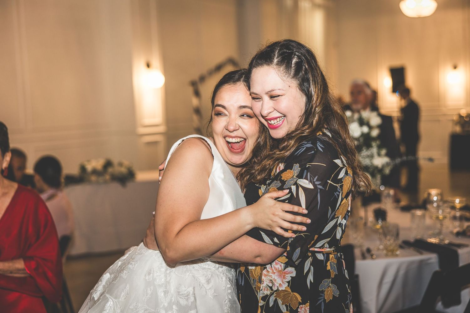Candid moments of joy and laughter shared between wedding guests at the reception.