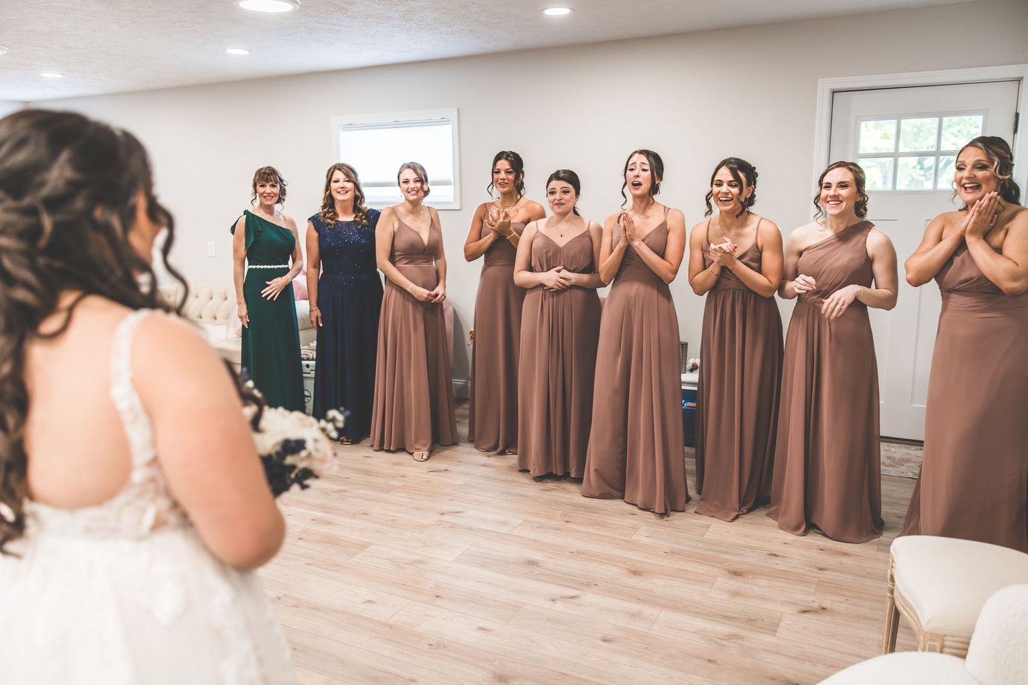 Bridesmaids in matching brown dresses line up during a wedding celebration.