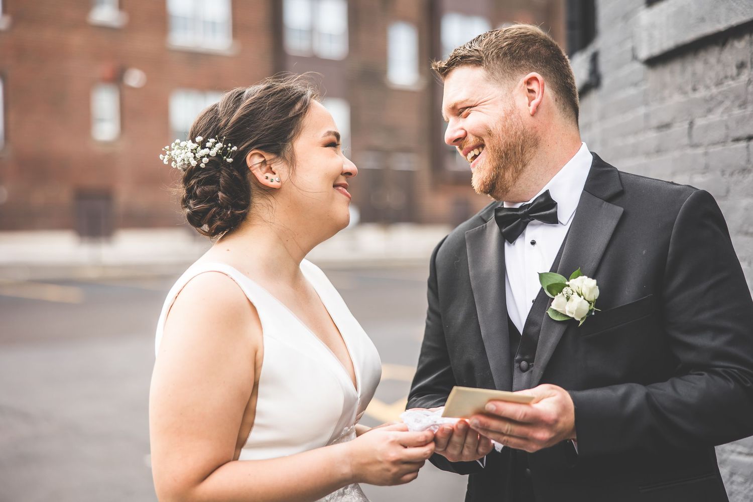 Close-up shot of wedding couple exchanging rings during an outdoor ceremony.