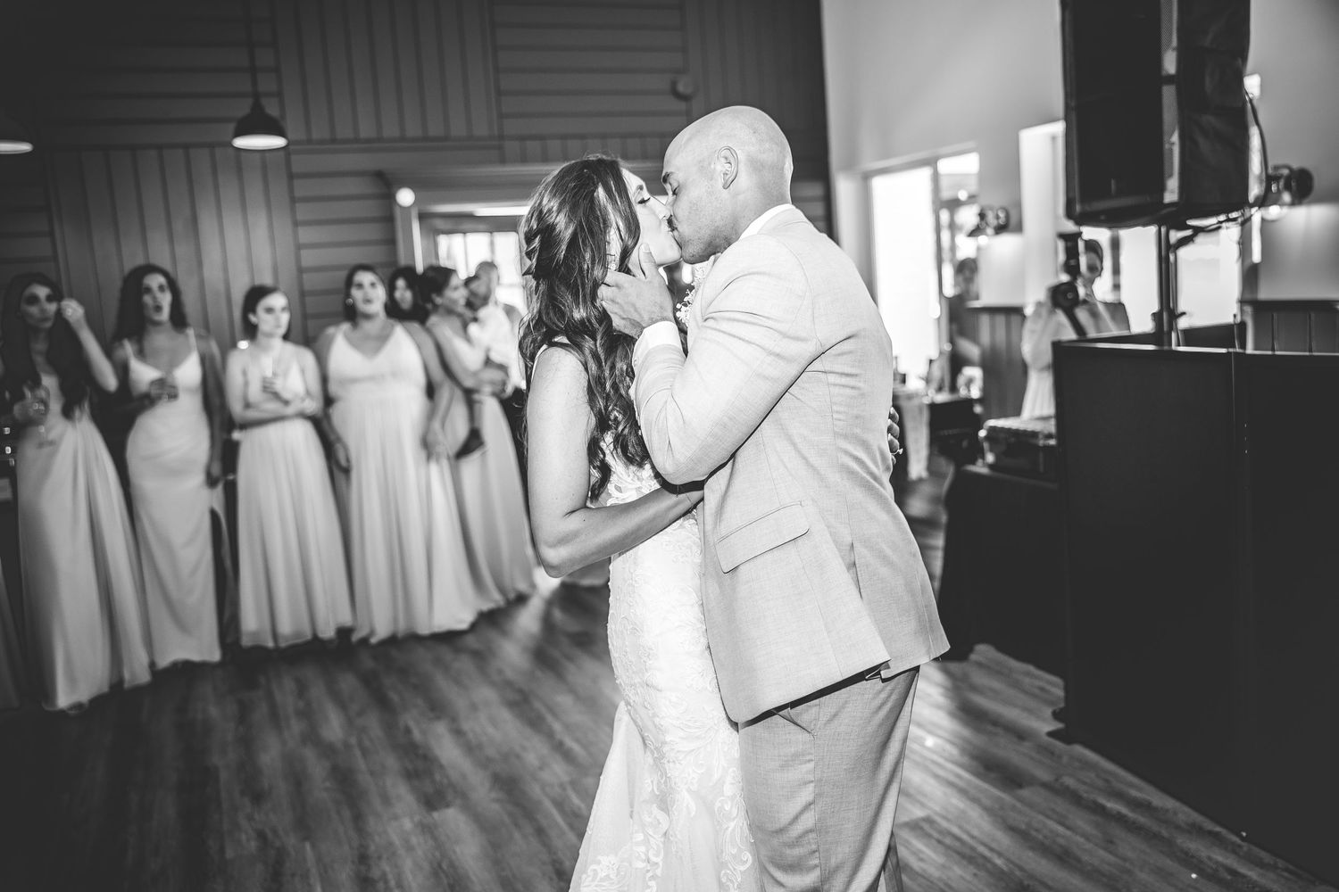 Wedding party dancing and celebrating on the dance floor at an indoor reception venue.