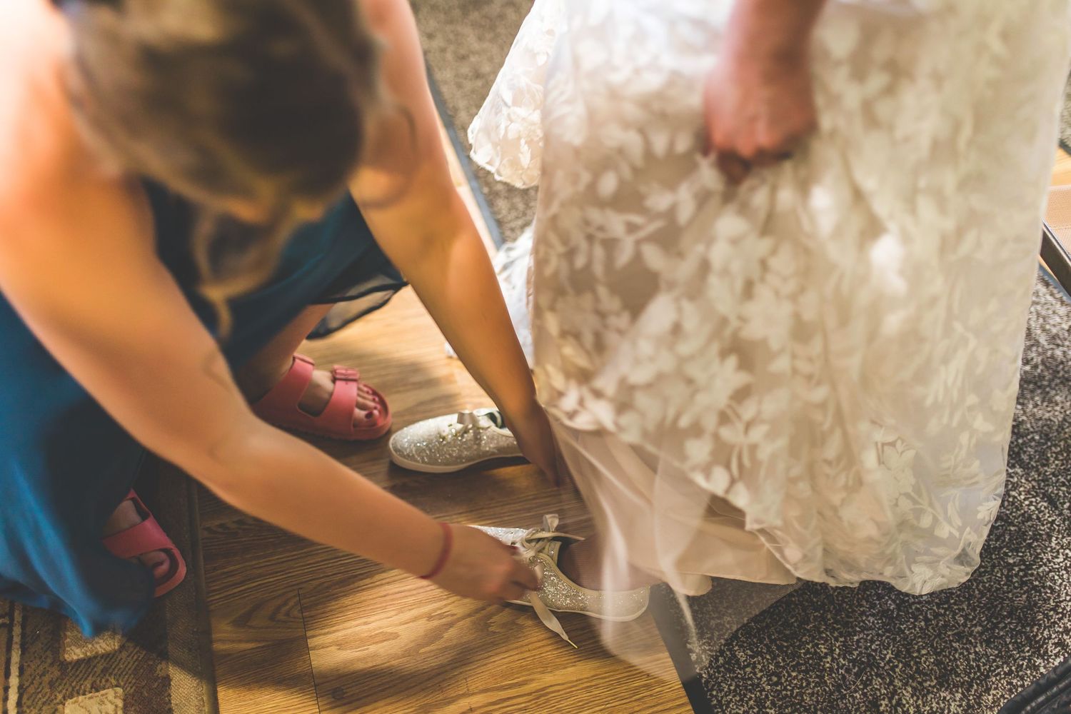 Close-up details of wedding dress preparations and final touches before the ceremony.