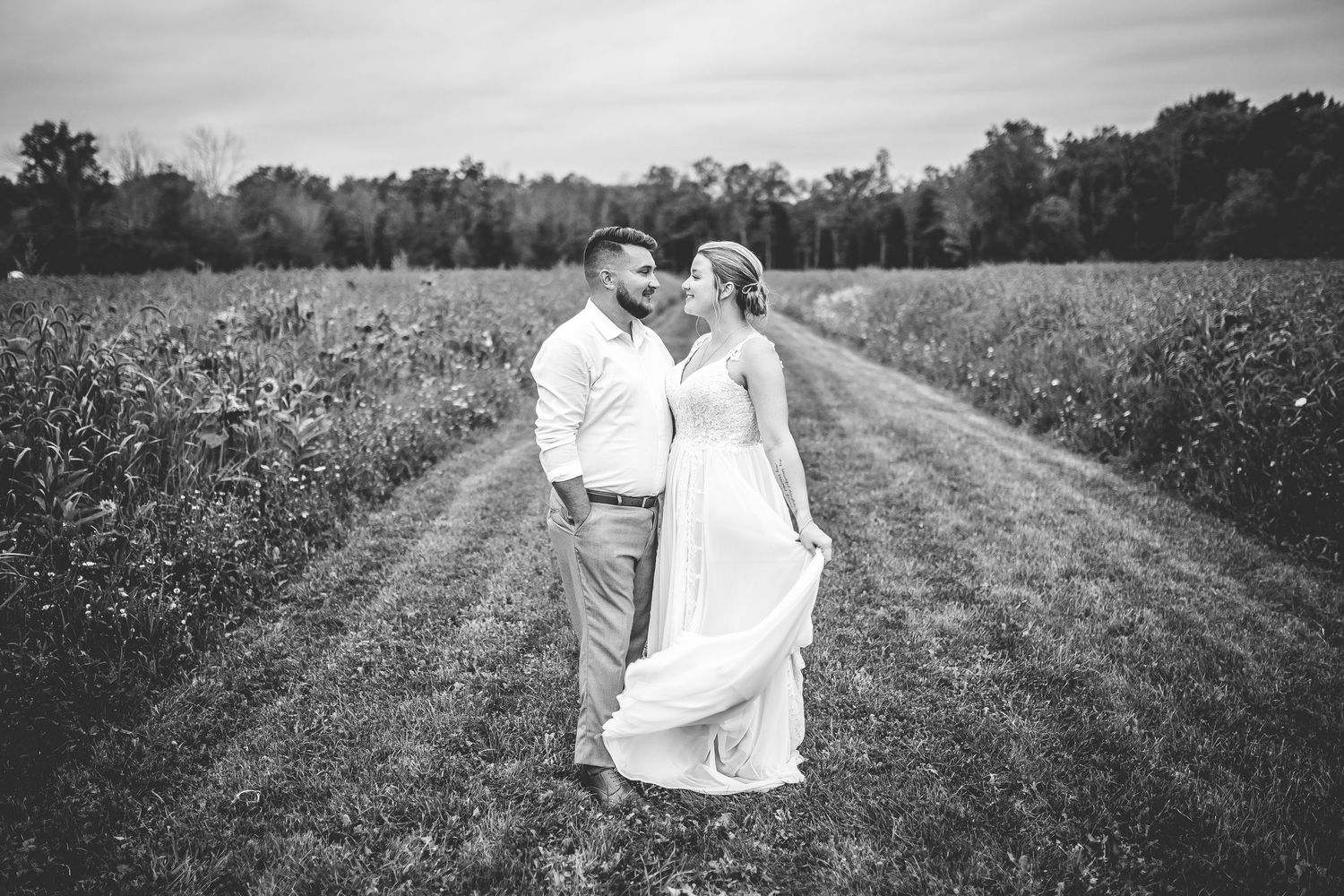 Black and white portrait of couple walking along a rural path.