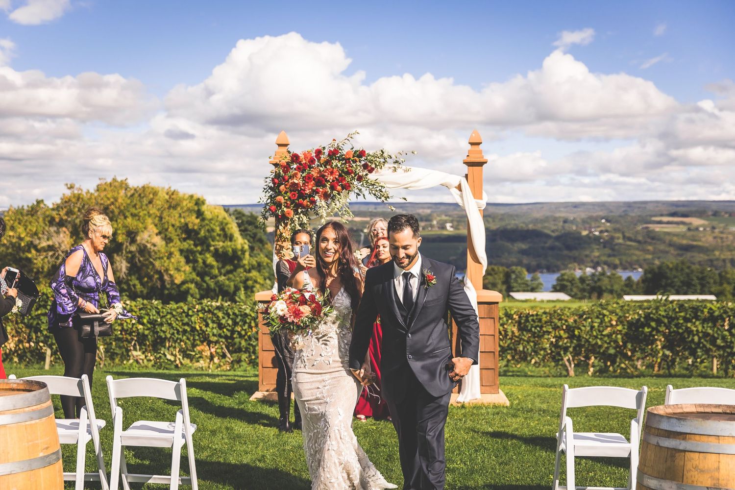 Scenic vineyard wedding venue with white chairs and natural landscape views.