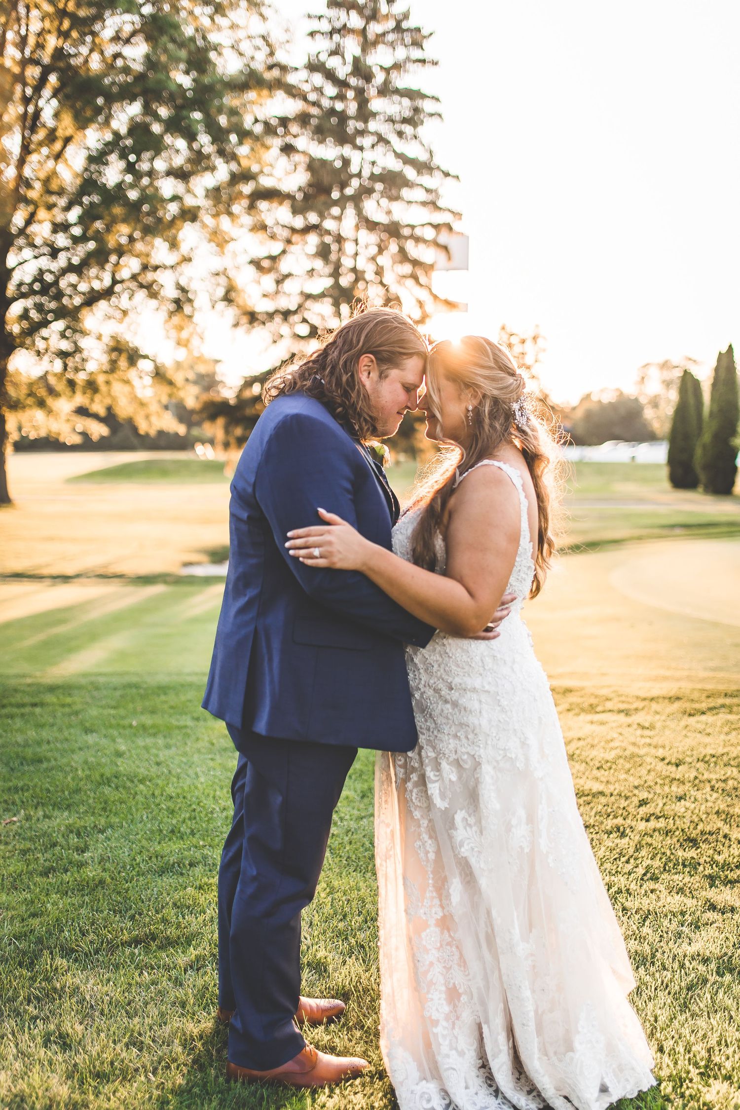 Intimate wedding moment captured during golden hour on a golf course.