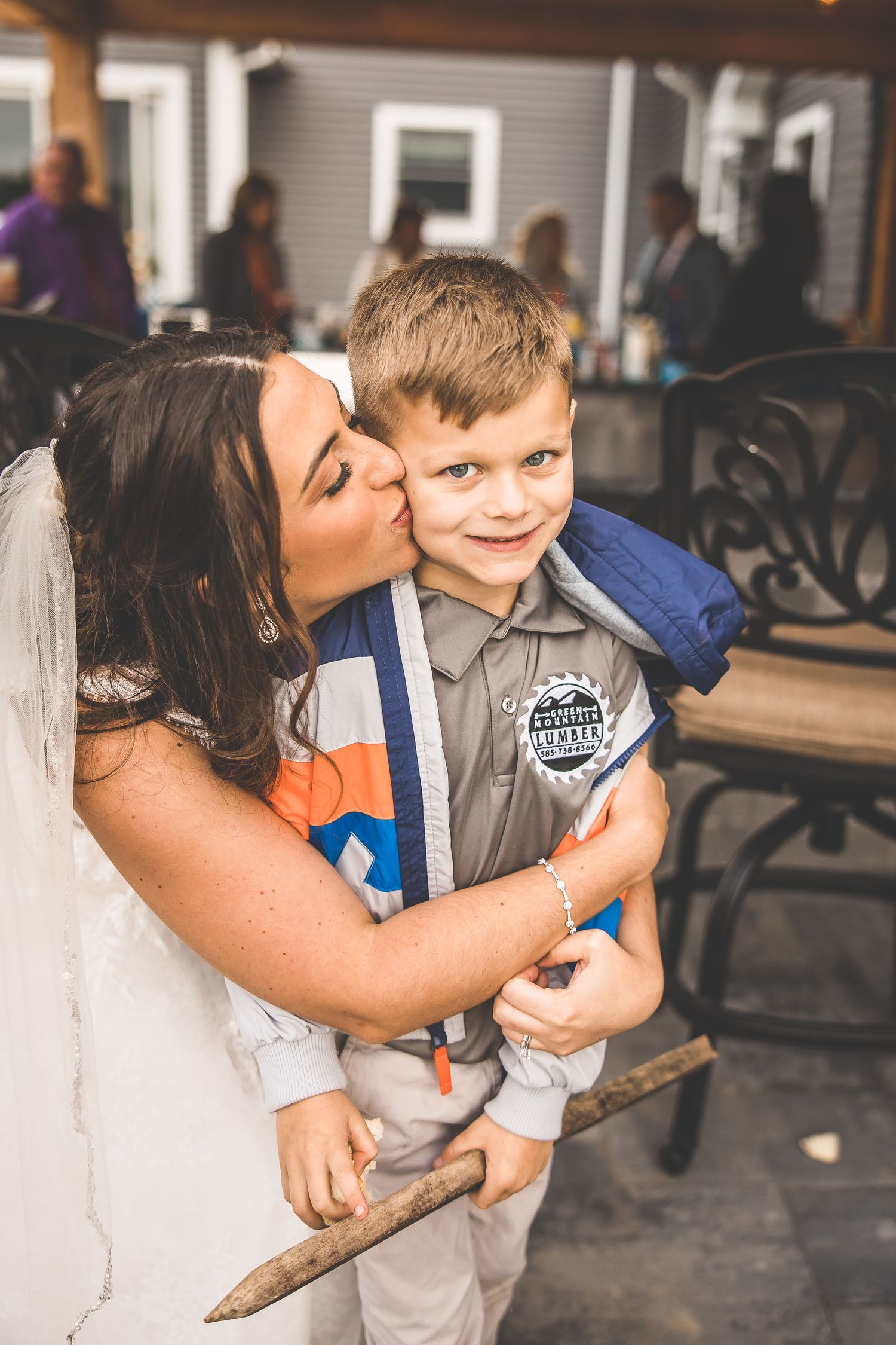 Sweet candid moment between bride and young ring bearer at wedding reception.