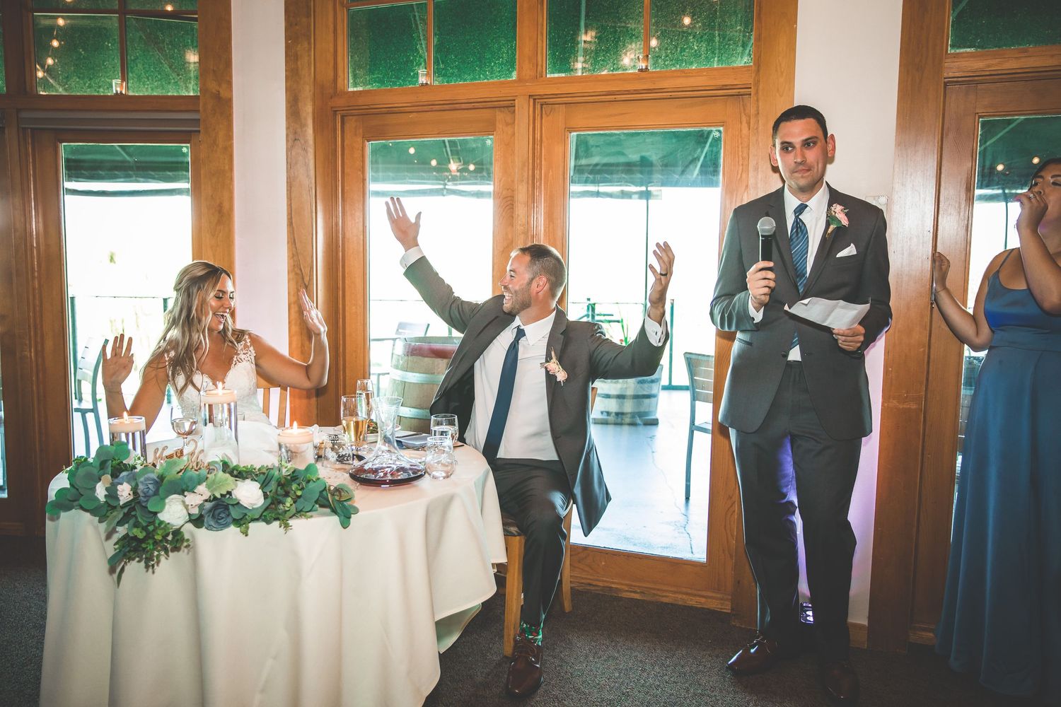 Wedding reception venue with wooden trim and green-tinted windows in panoramic view.
