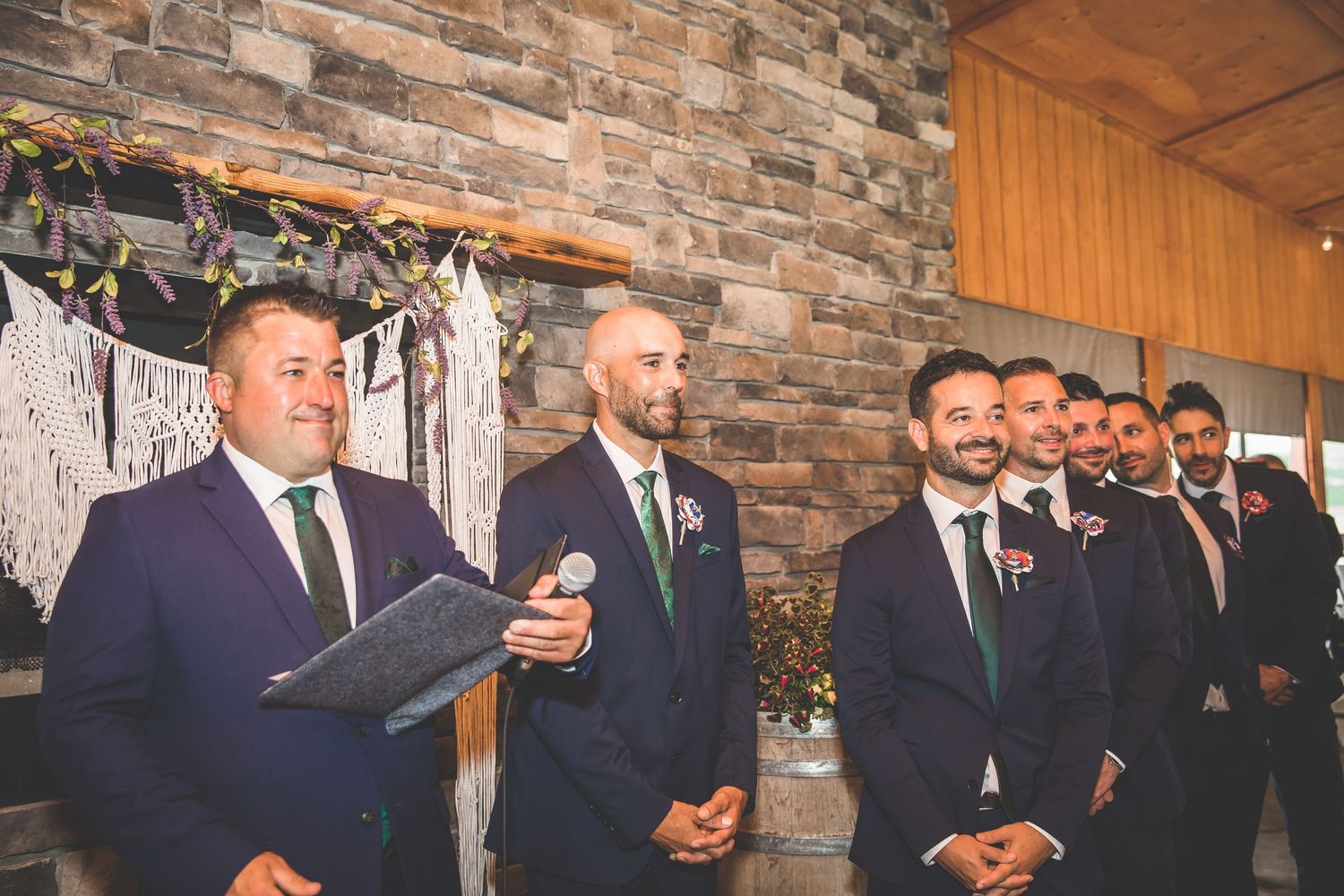 Wedding party reactions during emotional ceremony moment in rustic venue.