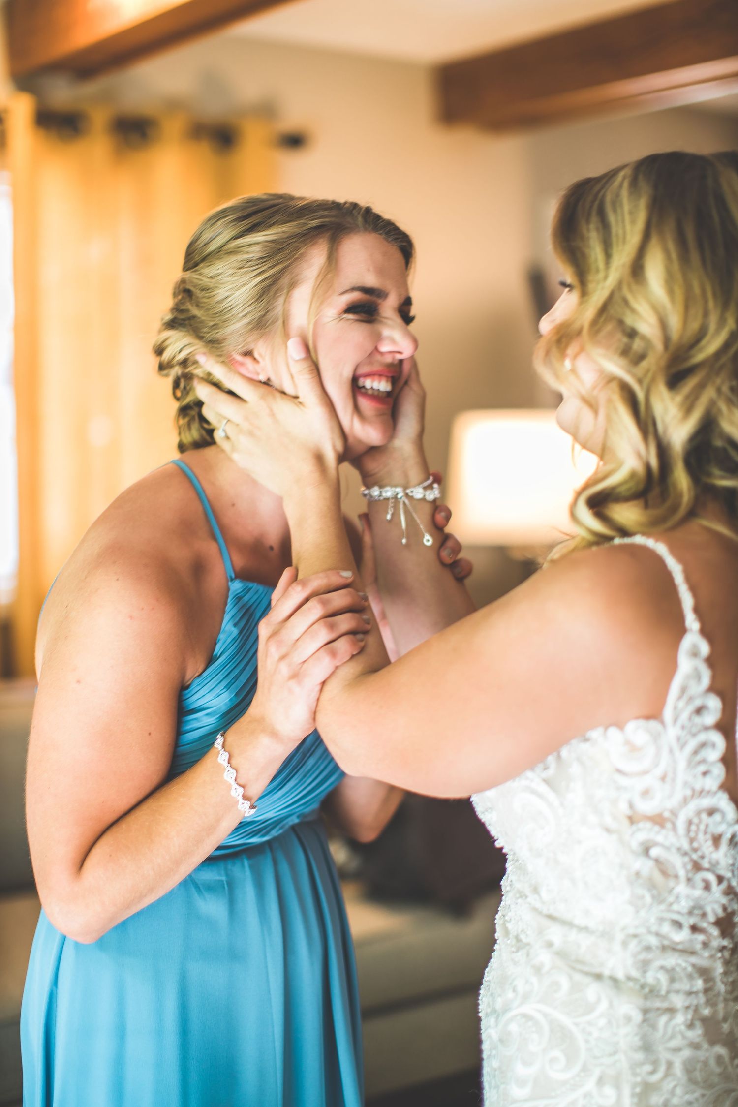 An emotional moment shared between two women during wedding preparations indoors.
