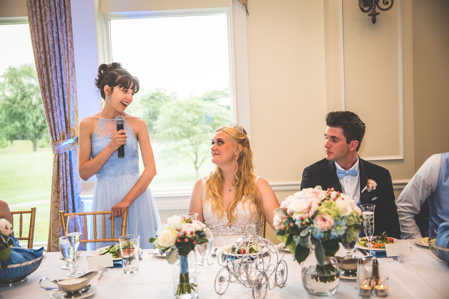 Wedding reception dining room with natural light streaming through large windows.