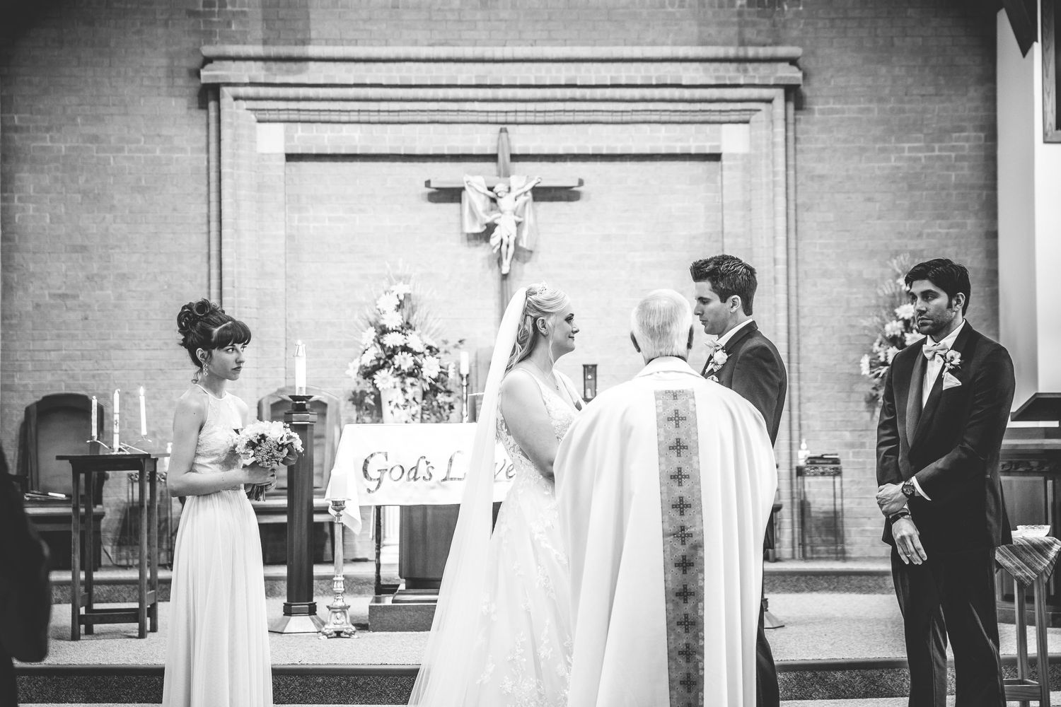 Black and white photo of wedding ceremony in church setting.