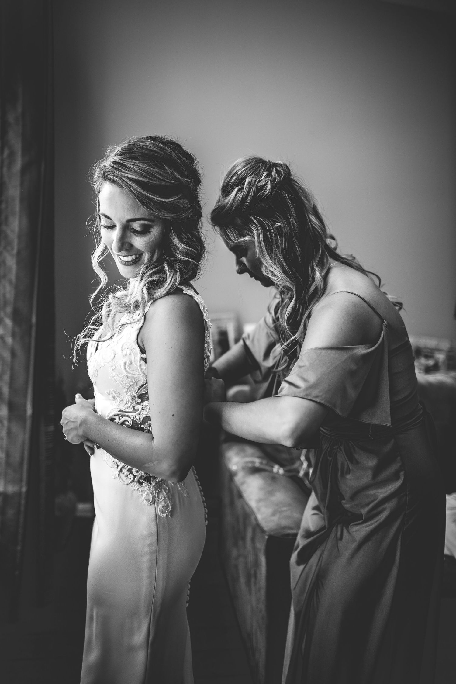 Black and white photo capturing intimate pre-wedding preparation moments.