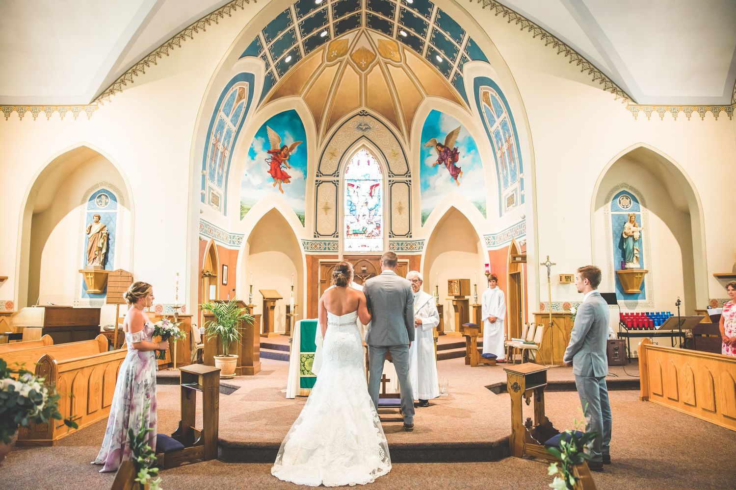 Church interior with vaulted ceilings and arched windows during wedding ceremony.