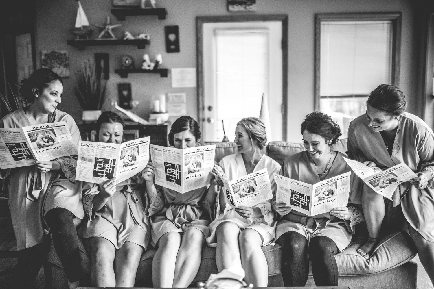 Wedding party members read newspapers together in a candid black and white photo sequence.