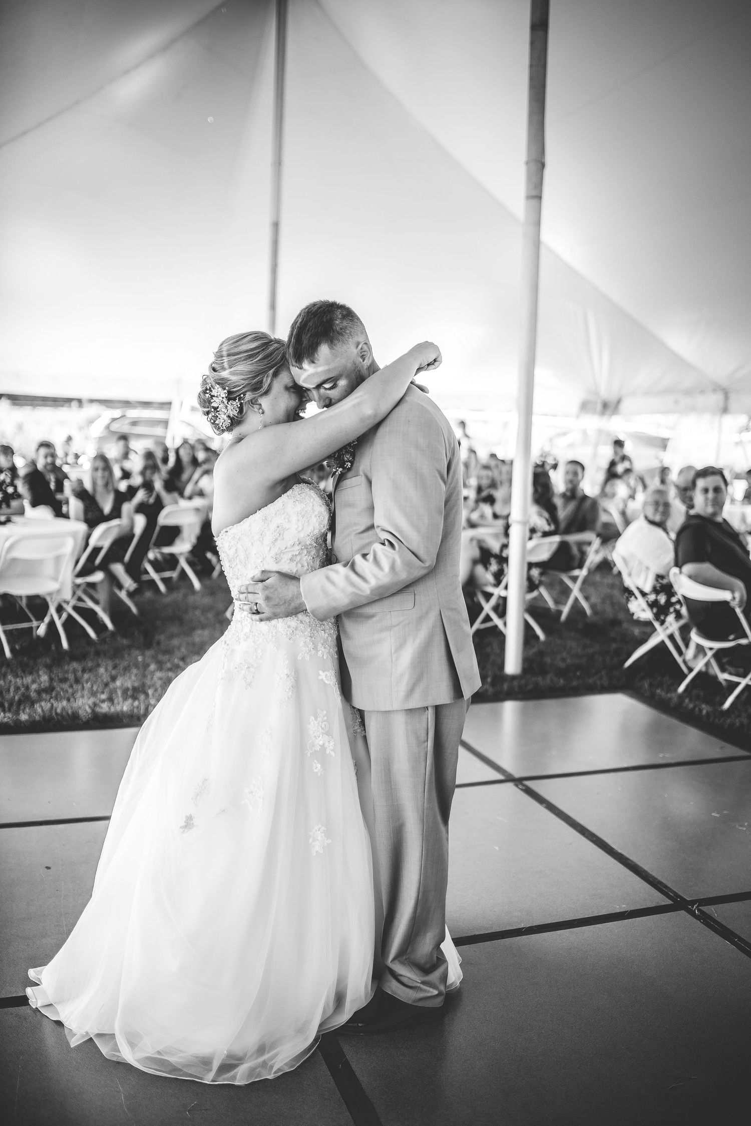 A romantic black and white photo captures a couple's intimate dance moment at their wedding reception.