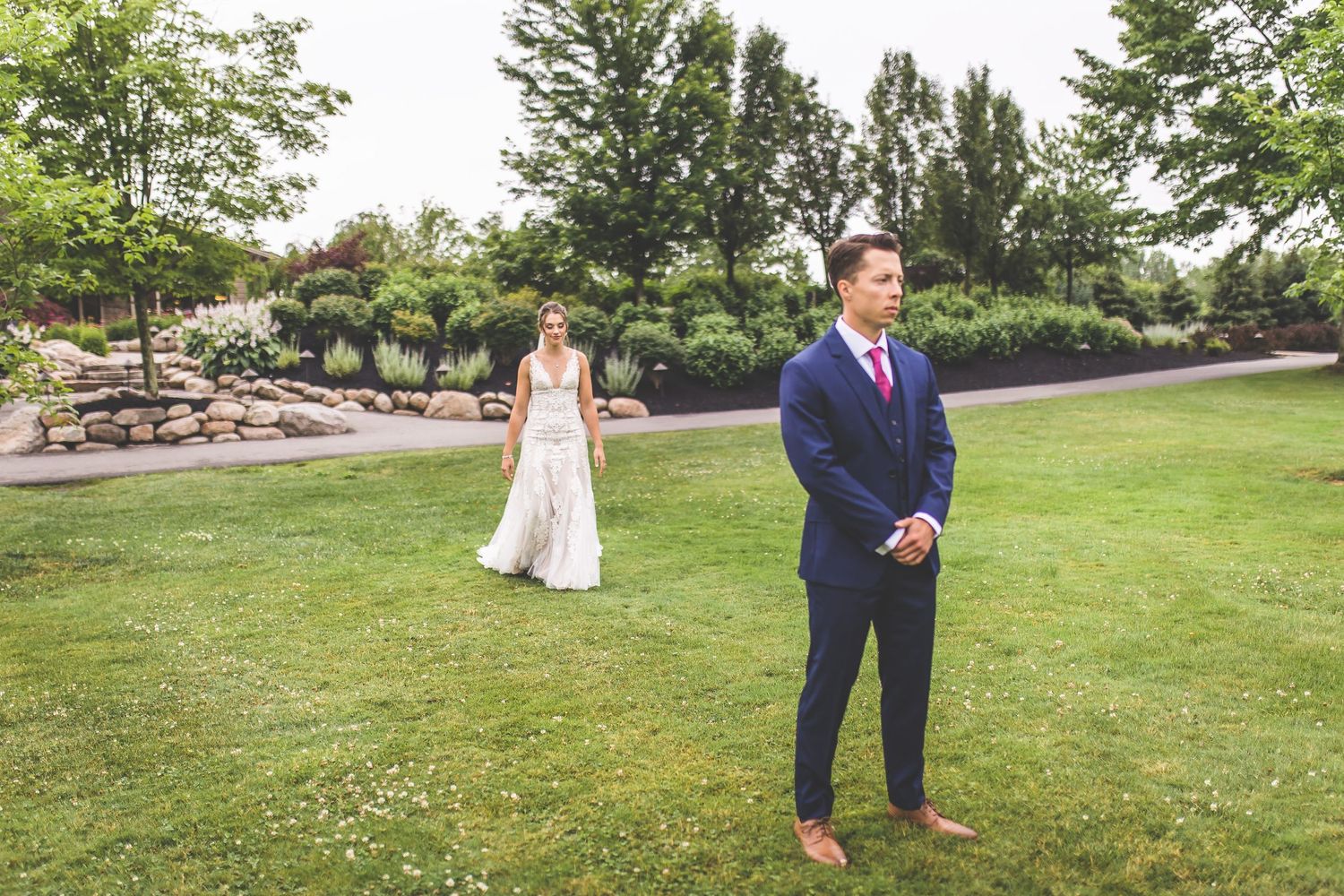 Wedding ceremony taking place on a green lawn with guests watching.