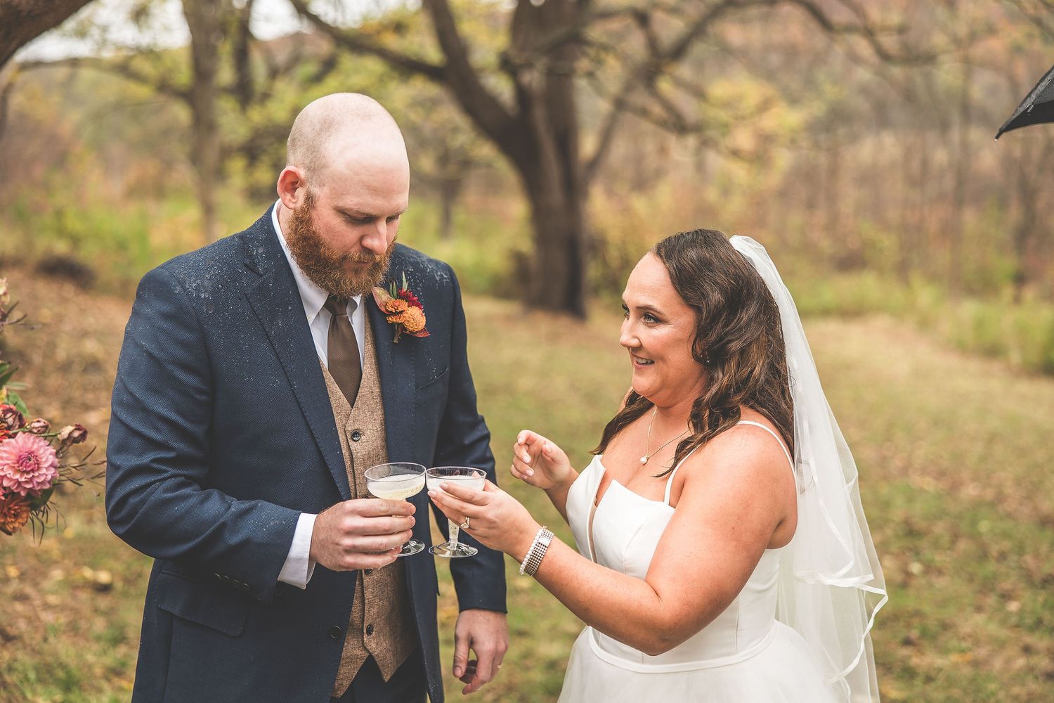 Couple participates in wedding ceremony traditions during outdoor autumn celebration.