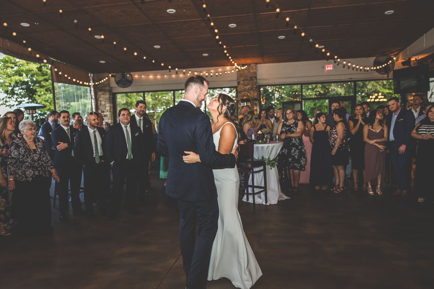 Elegant wedding reception venue with string lights and dancing guests.