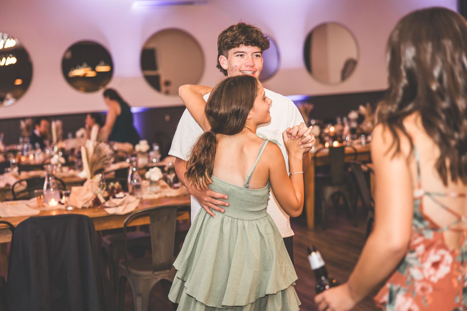 Wedding reception dance party with purple mood lighting and festive atmosphere.