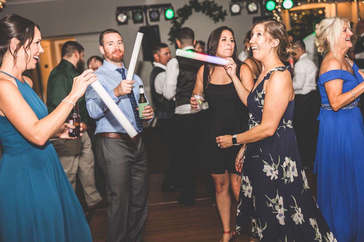Lively dance floor scene at wedding reception with guests in formal attire.