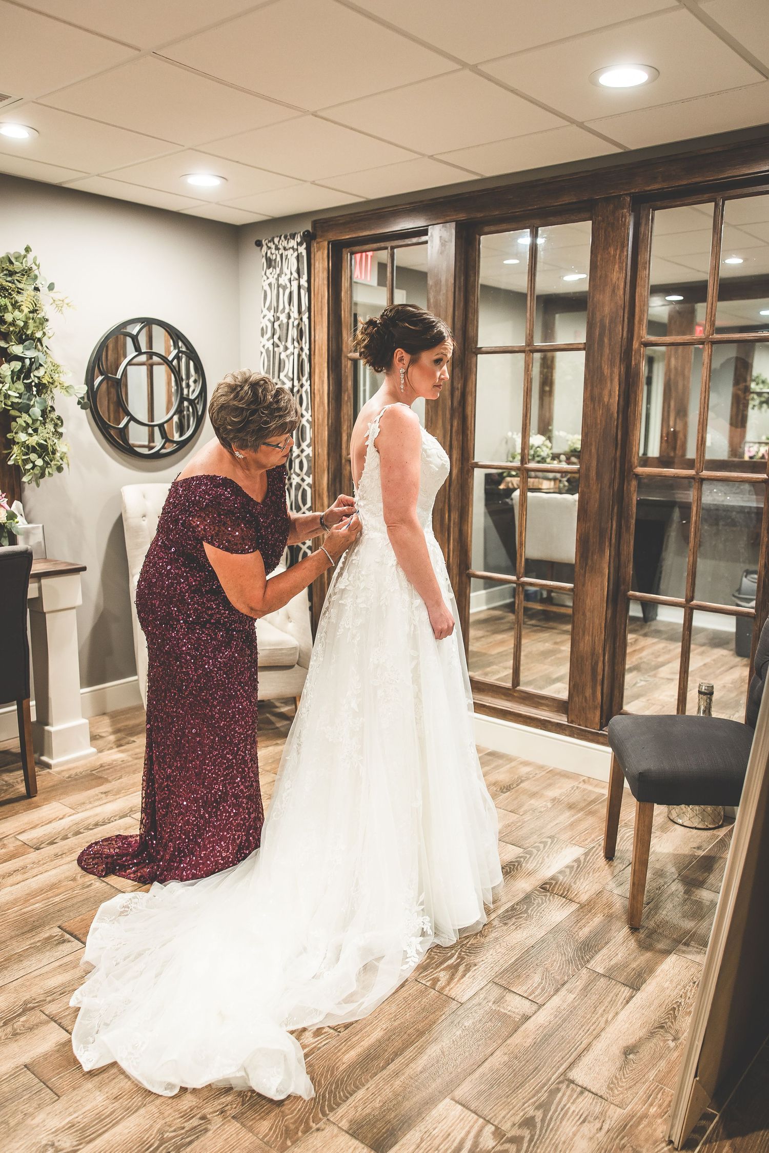 A wedding dress fitting session in a bridal boutique with wooden floors and warm lighting.