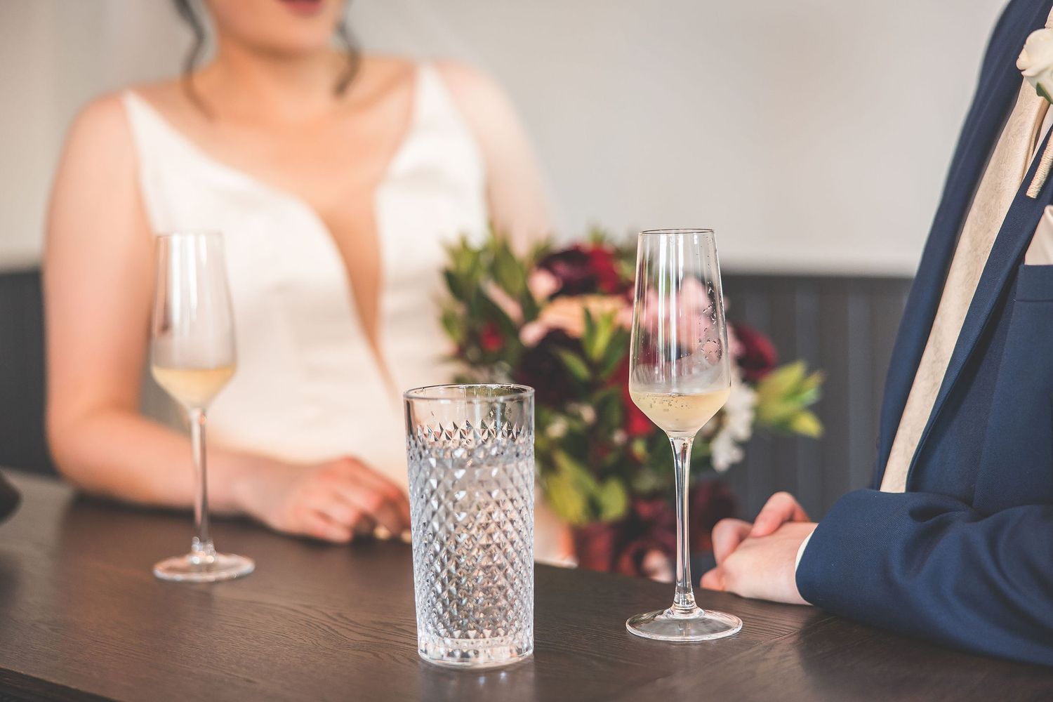 Elegant wedding reception table settings with crystal glassware and floral arrangements.