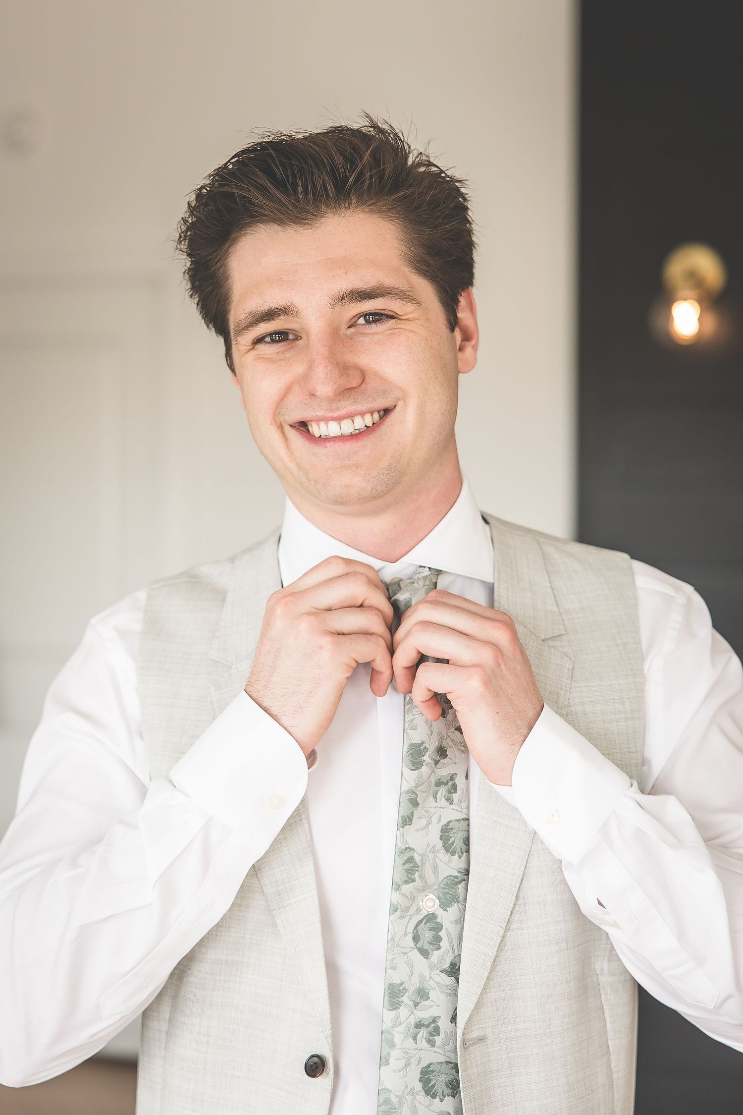 A series of joyful getting ready photos showing someone adjusting their tie and smiling in formal attire.