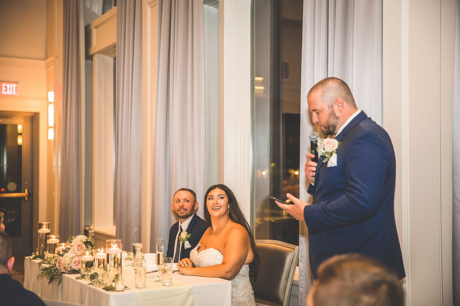 Guests celebrating during evening wedding reception in elegant ballroom setting.