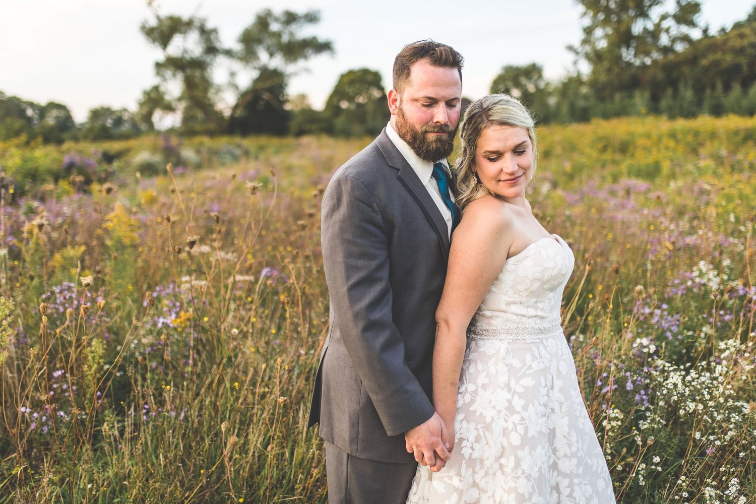 Couple shares intimate moments among wildflowers during their wedding photoshoot.