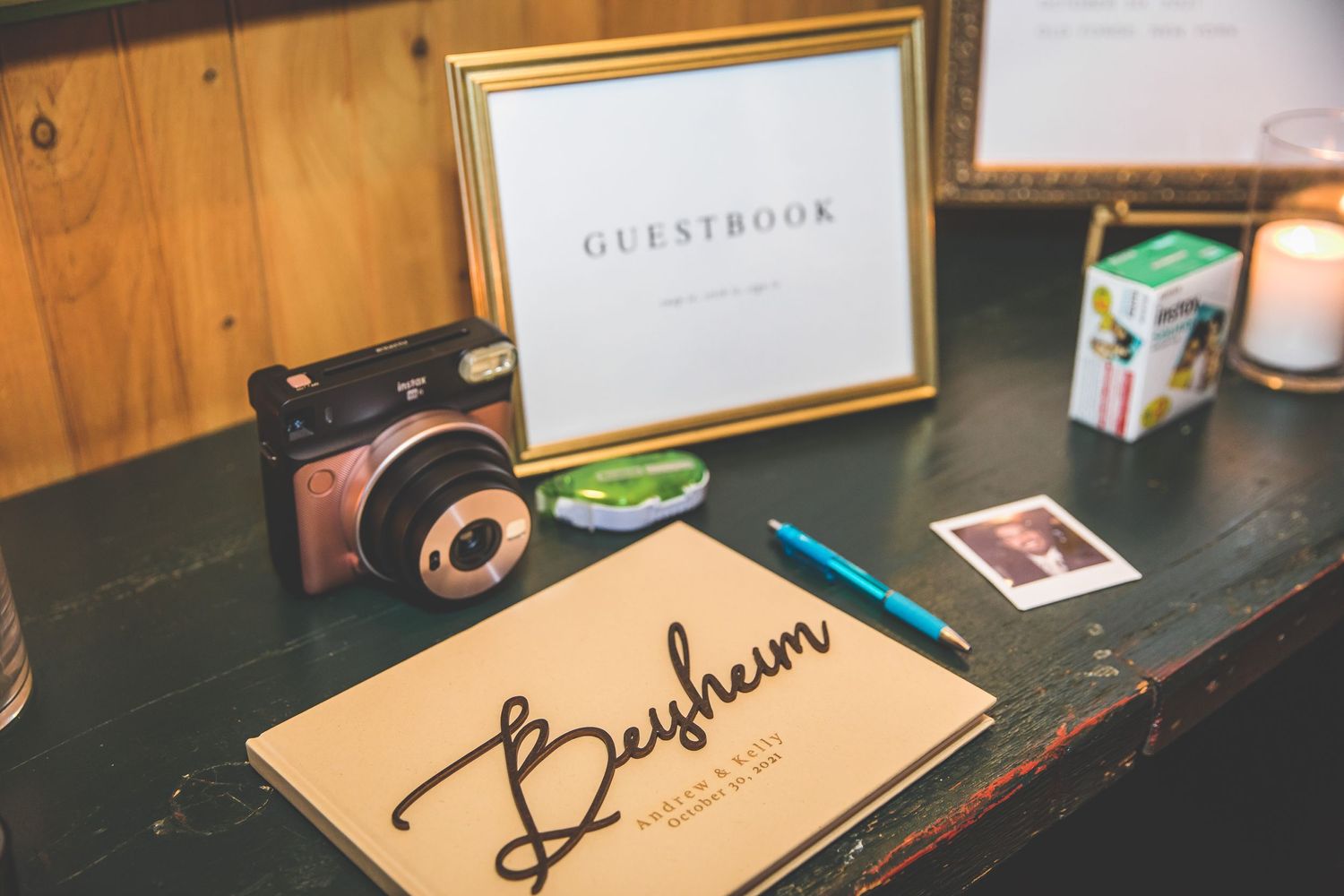 Wedding guestbook and signature items displayed on dark wooden table.