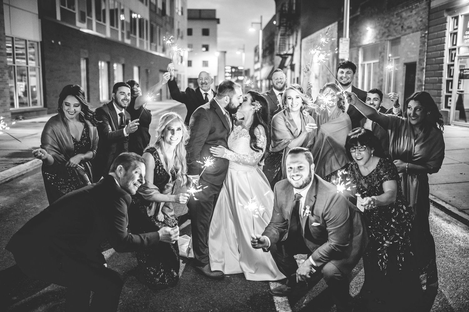 Candid black and white shot of wedding guests enjoying nighttime festivities.
