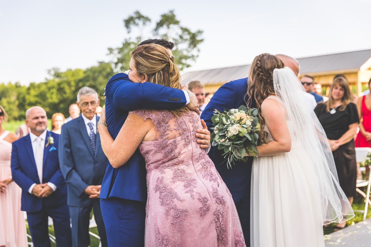 Wedding ceremony in progress under an elegant white gazebo with guests watching.