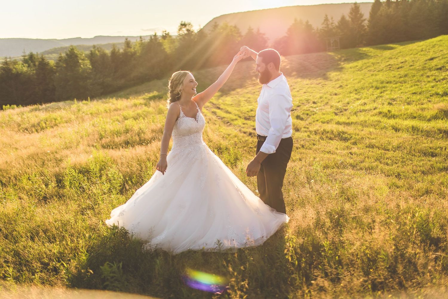 Romantic sunset wedding photos in a mountain meadow with warm lighting.