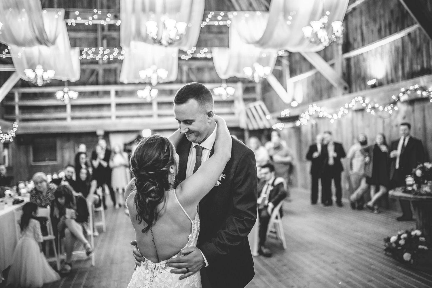 Black and white reception photos show couples dancing in spacious venue with dramatic lighting.