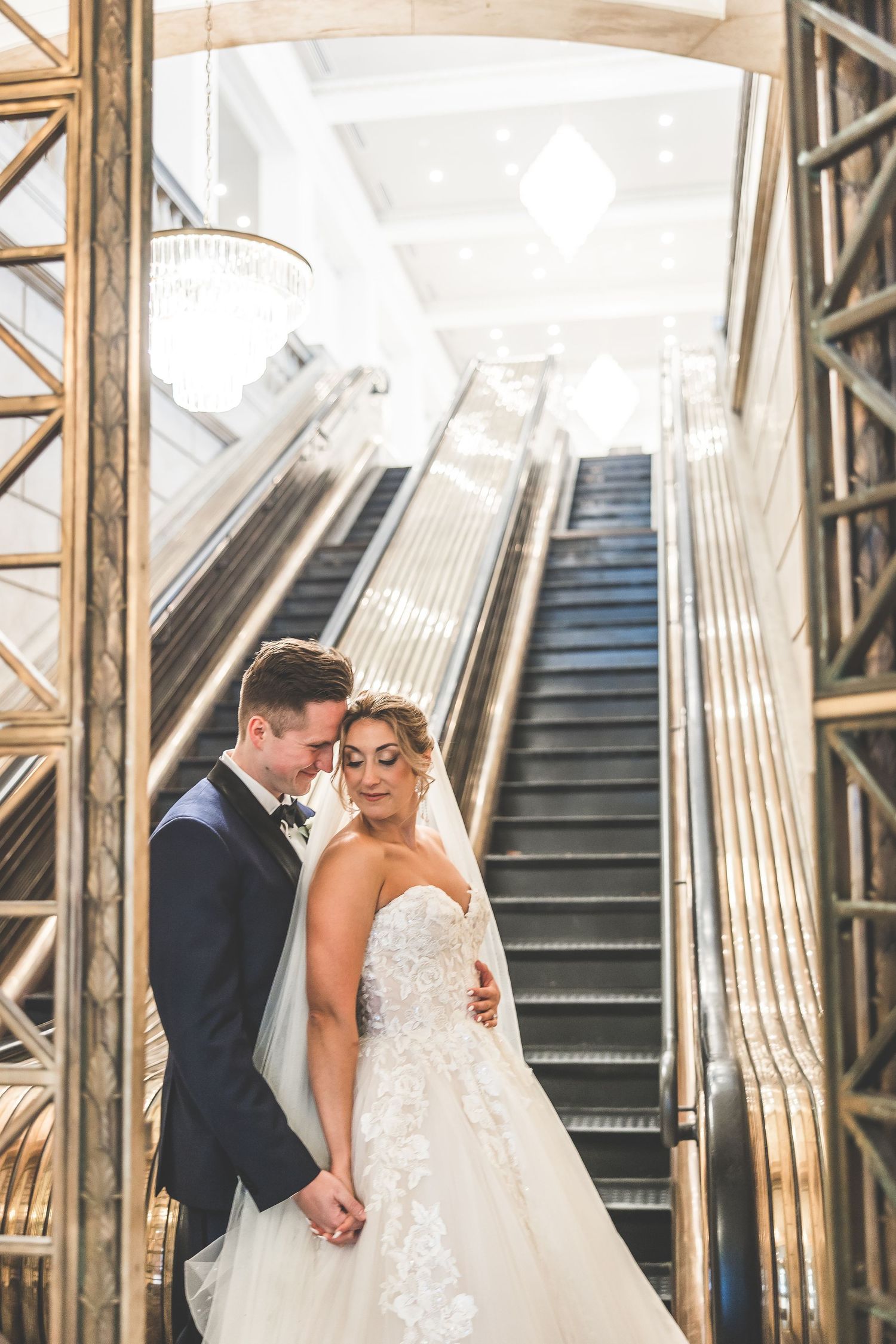 Art deco staircase with gold railings and geometric patterns creates dramatic wedding photo backdrop.