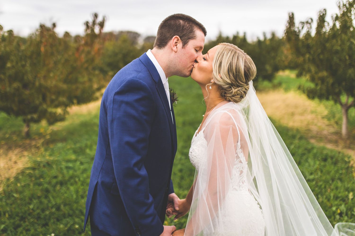 Romantic wedding portraits taken in a scenic outdoor setting during golden hour.