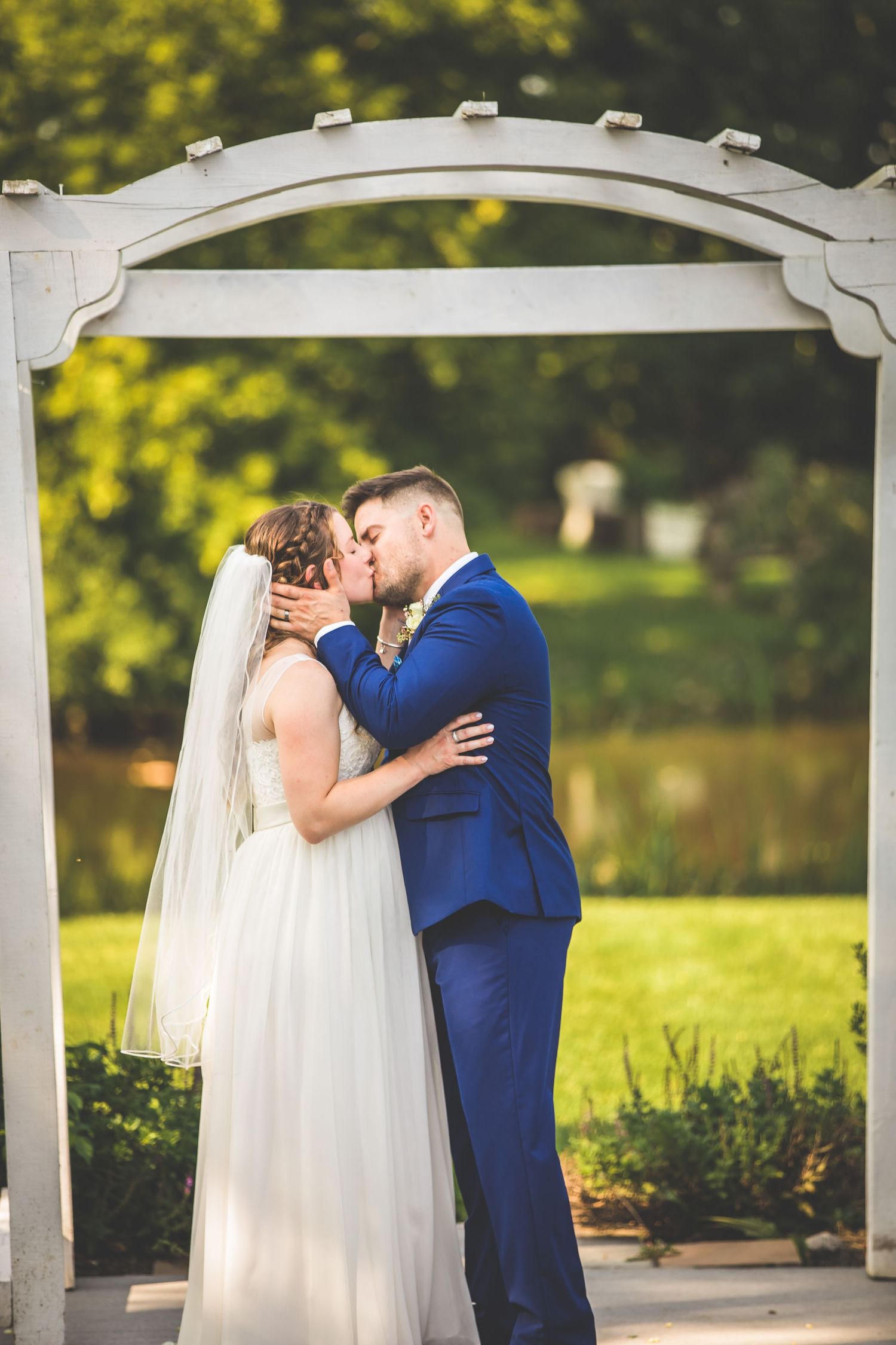 Romantic wedding ceremony moments captured under a white pergola with golden sunlight.