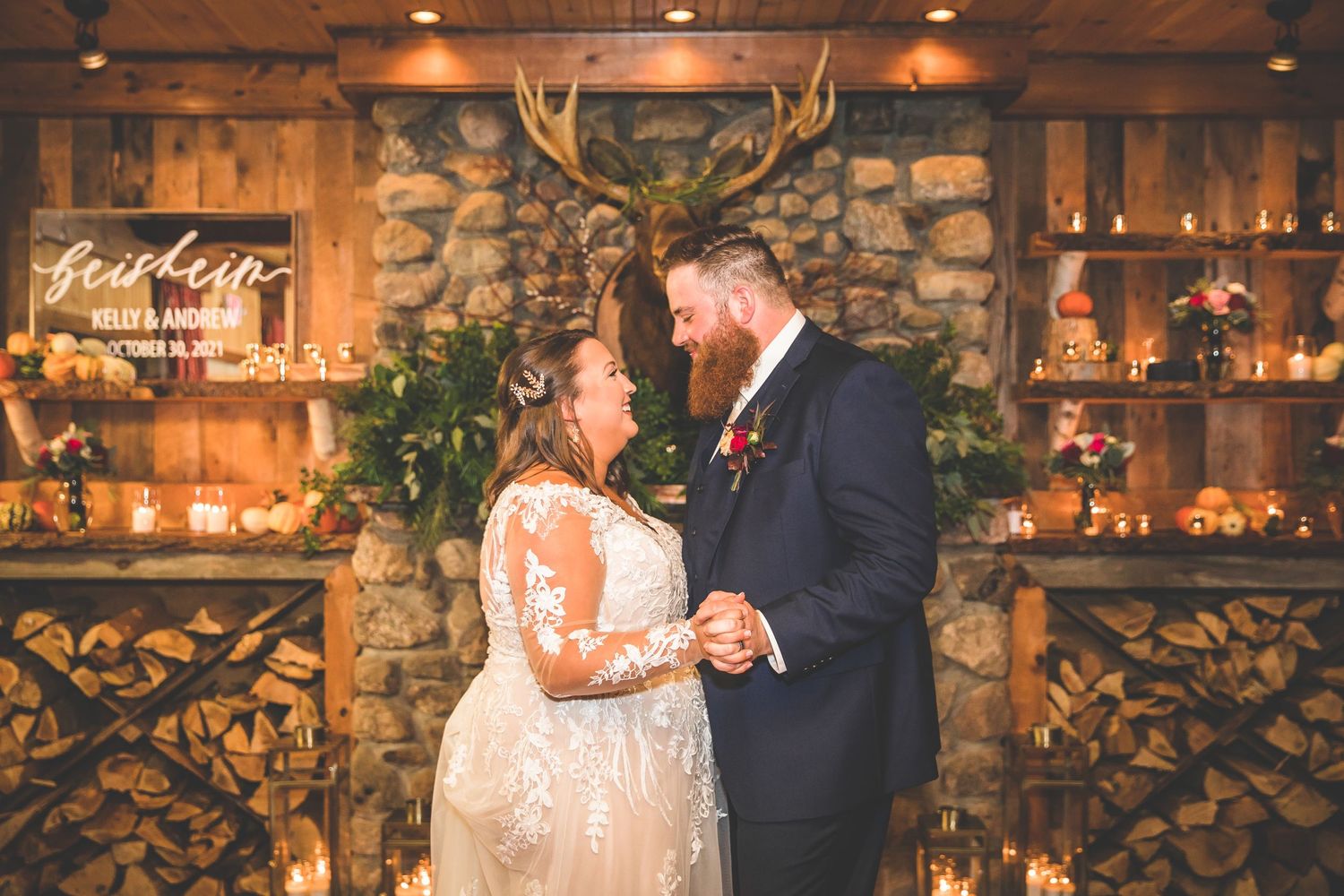 Couple shares their first dance in a rustic venue with stone walls and wooden beams.