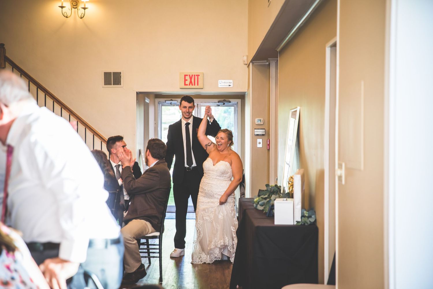 Wedding ceremony venue with warm lighting and guests gathering indoors.