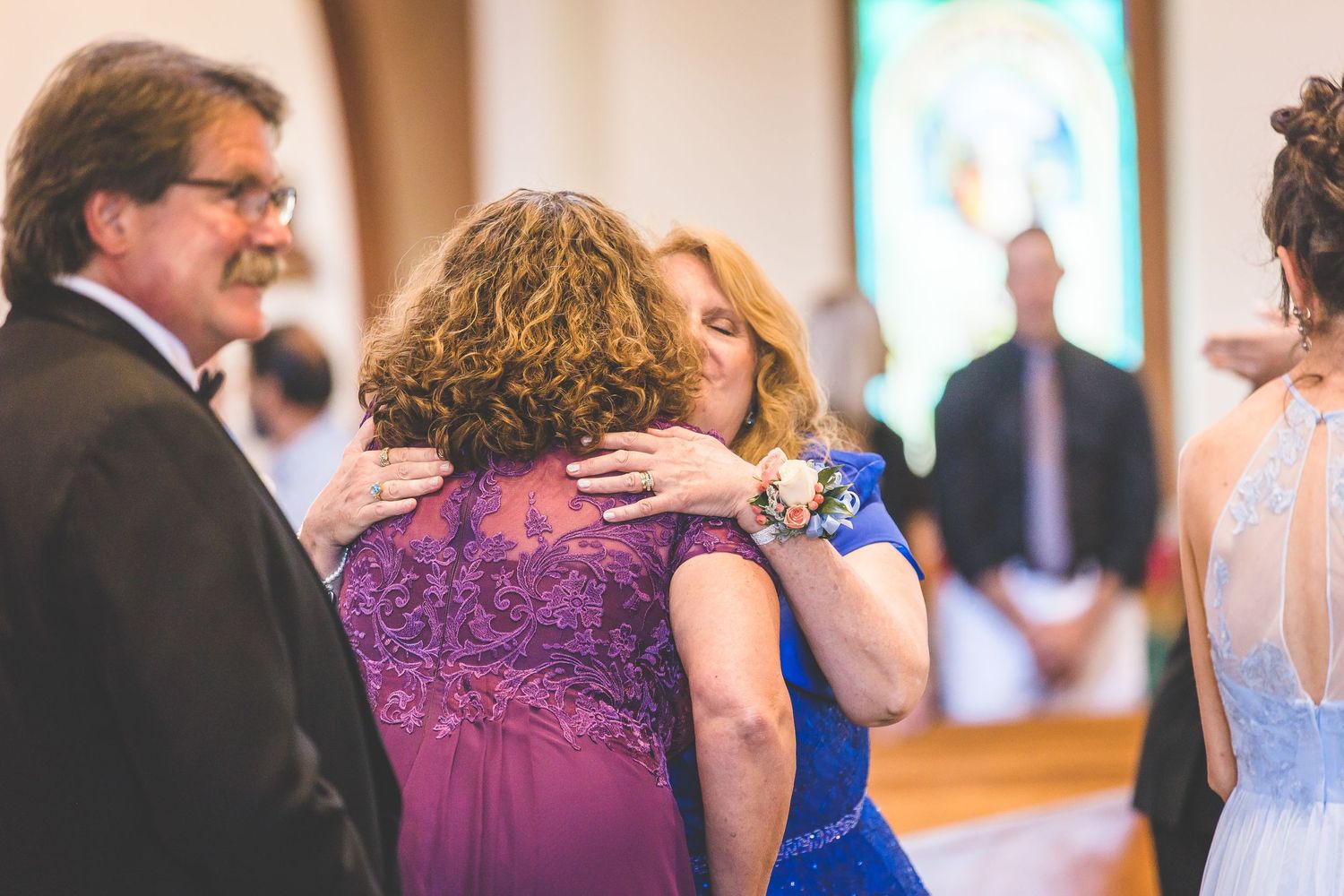 Wedding guests in colorful formal attire during ceremony.