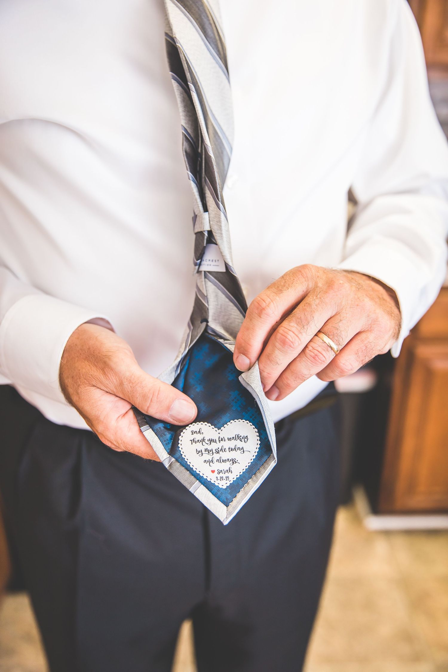 Close-up sequence showing hands holding a heart-shaped note at a wedding.