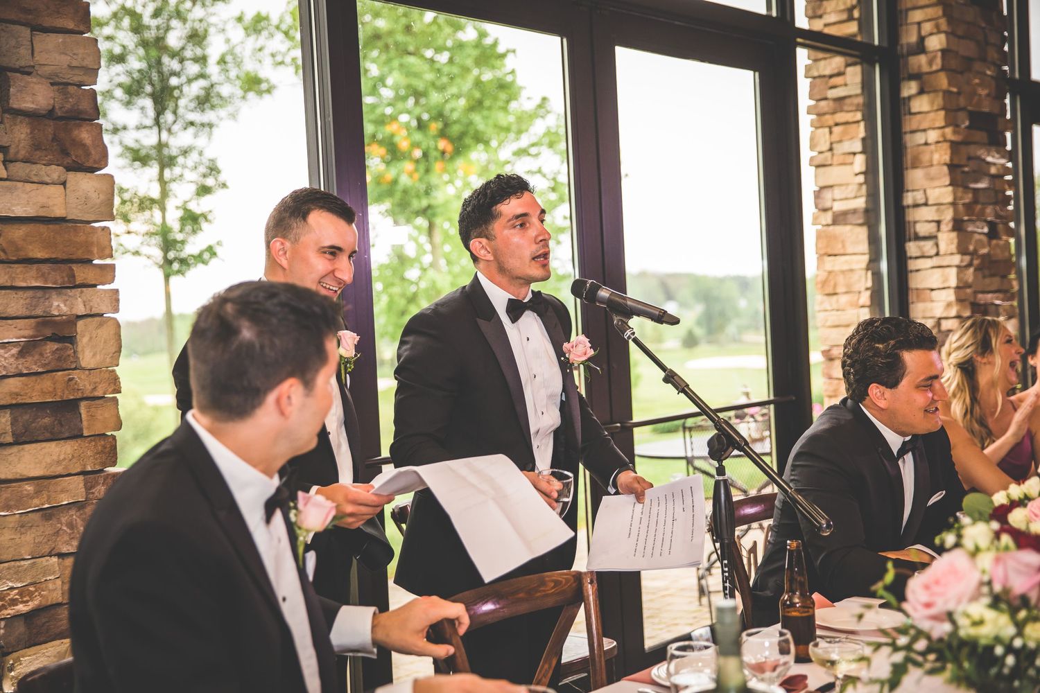 Musicians perform at an elegant wedding reception with stone pillars and floral decorations.