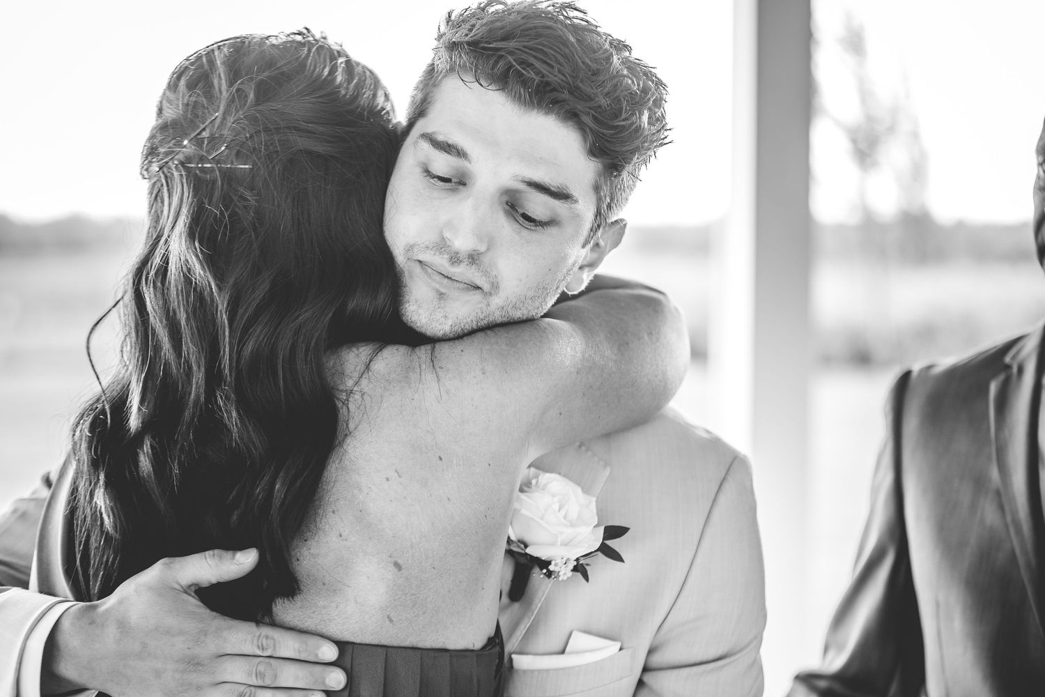 Emotional black and white candid moments shared between wedding party members.