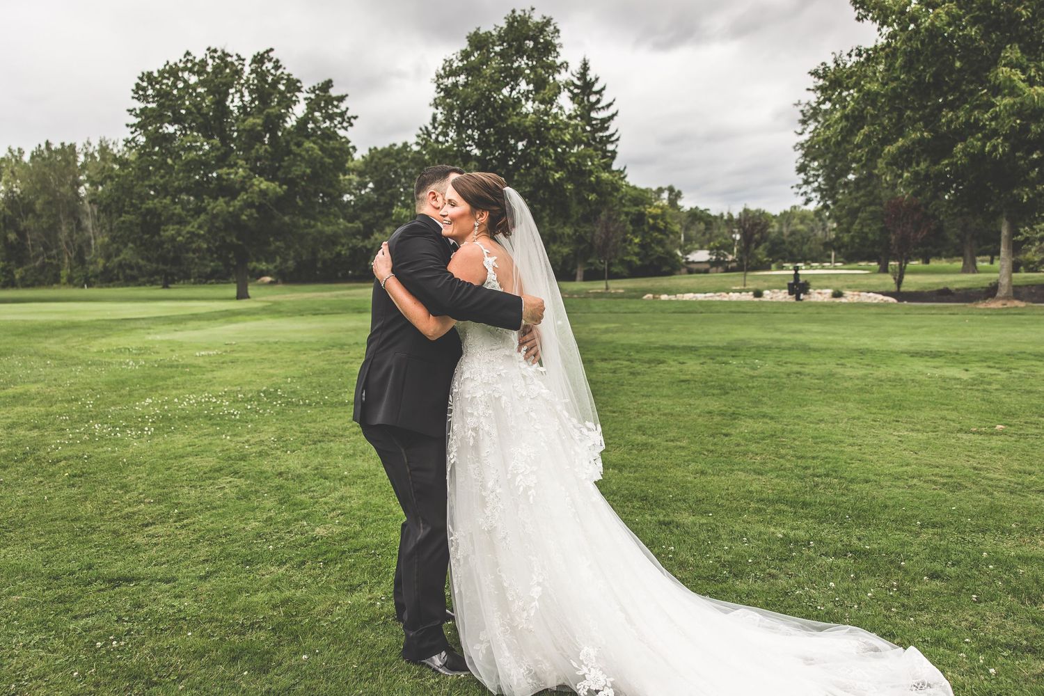 Wedding couple portraits taken on a scenic golf course with natural landscaping.