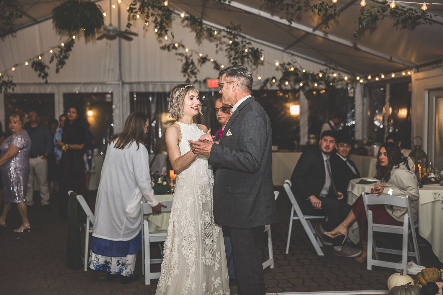 Evening wedding reception with ambient lighting and dancing guests.
