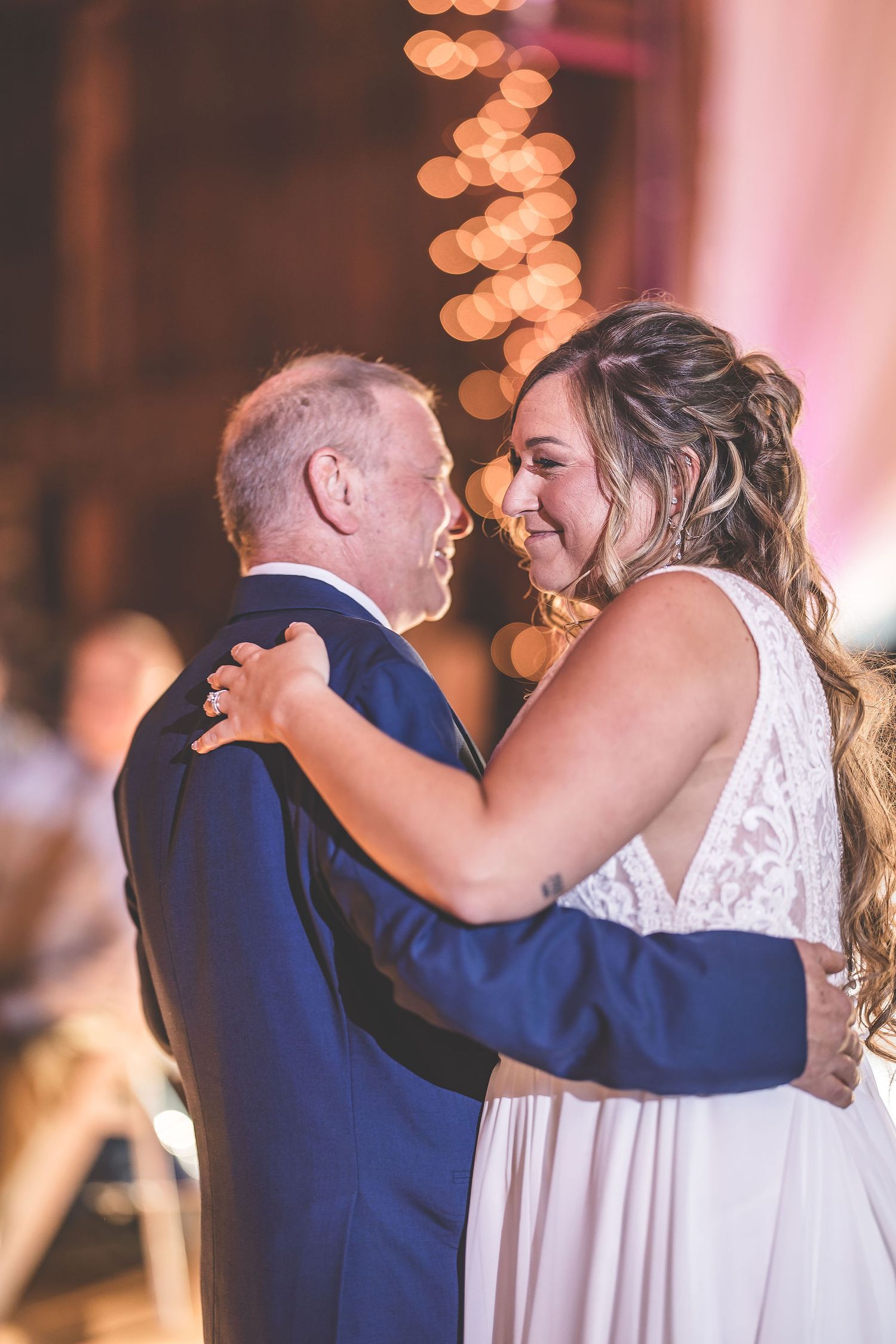 Joyful dance sequence showing laughter and embraces at a rustic wedding celebration.